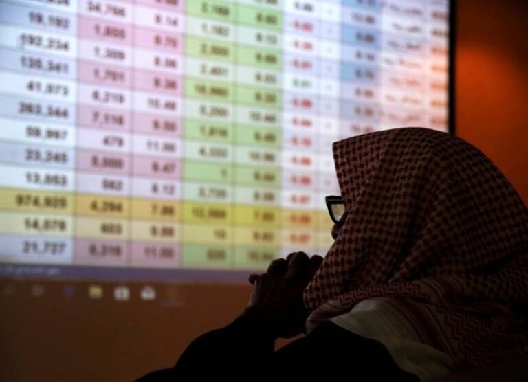 FILE PHOTO: A Saudi trader monitors stocks at the Saudi stock market in Riyadh