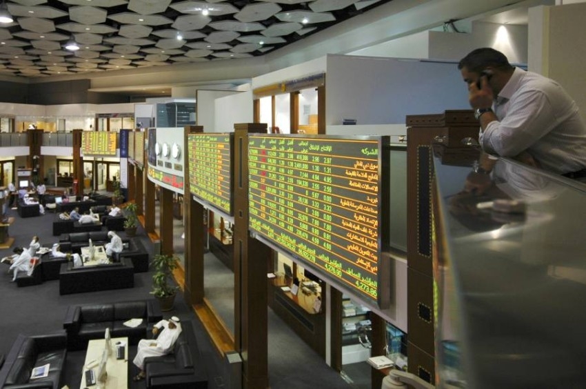 Investors mingle on the trading floor of the Dubai Financial Market during operating hours in the Dubai World Trade Center in Dubai