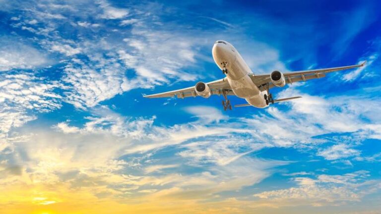 Commercial airplane flying in beautiful sky at sunset,travel con