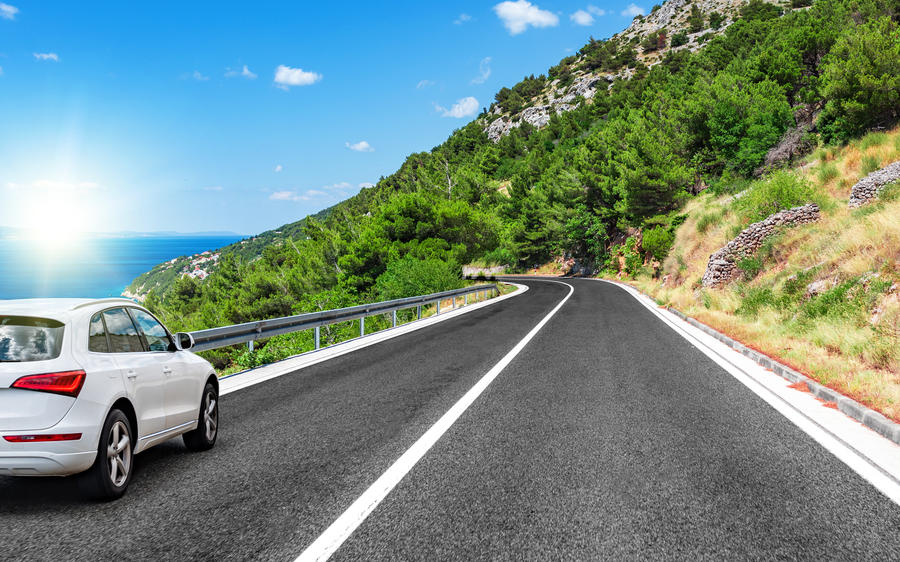 Car rushes along the road to the sea.