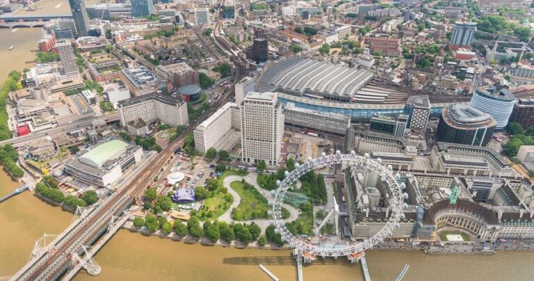 Helicopter view of London along Thames river with Waterloo train