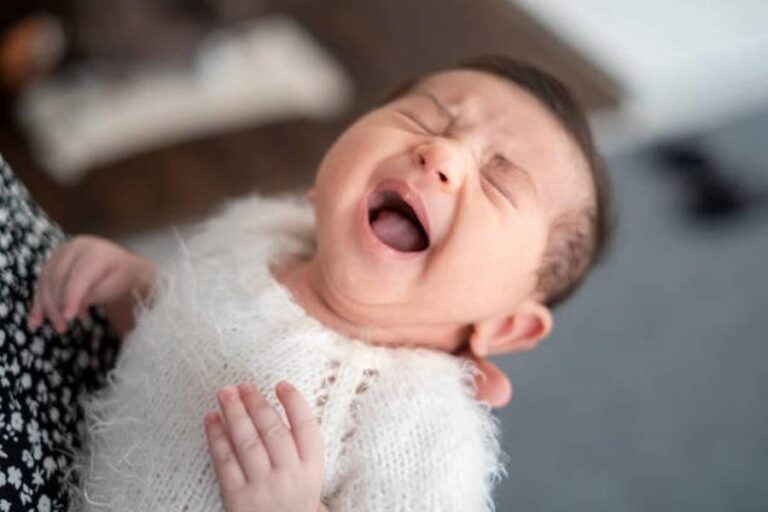 Newborn baby crying in mother hands