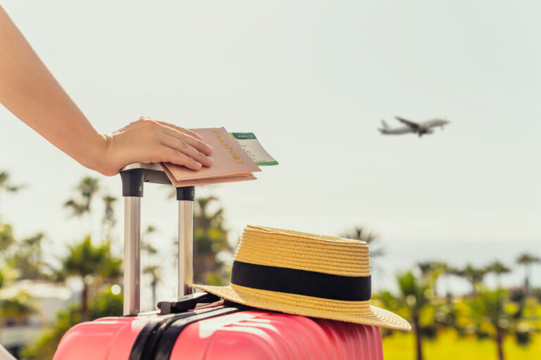 Woman,With,Pink,Suitcase,And,Passport,With,Boarding,Pass,Standing