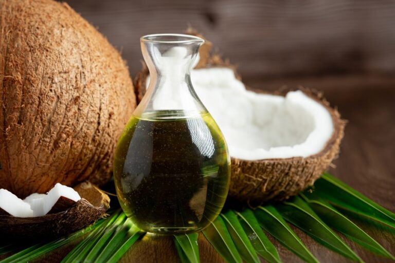 a jug of coconut oil whit coconut put on dark background