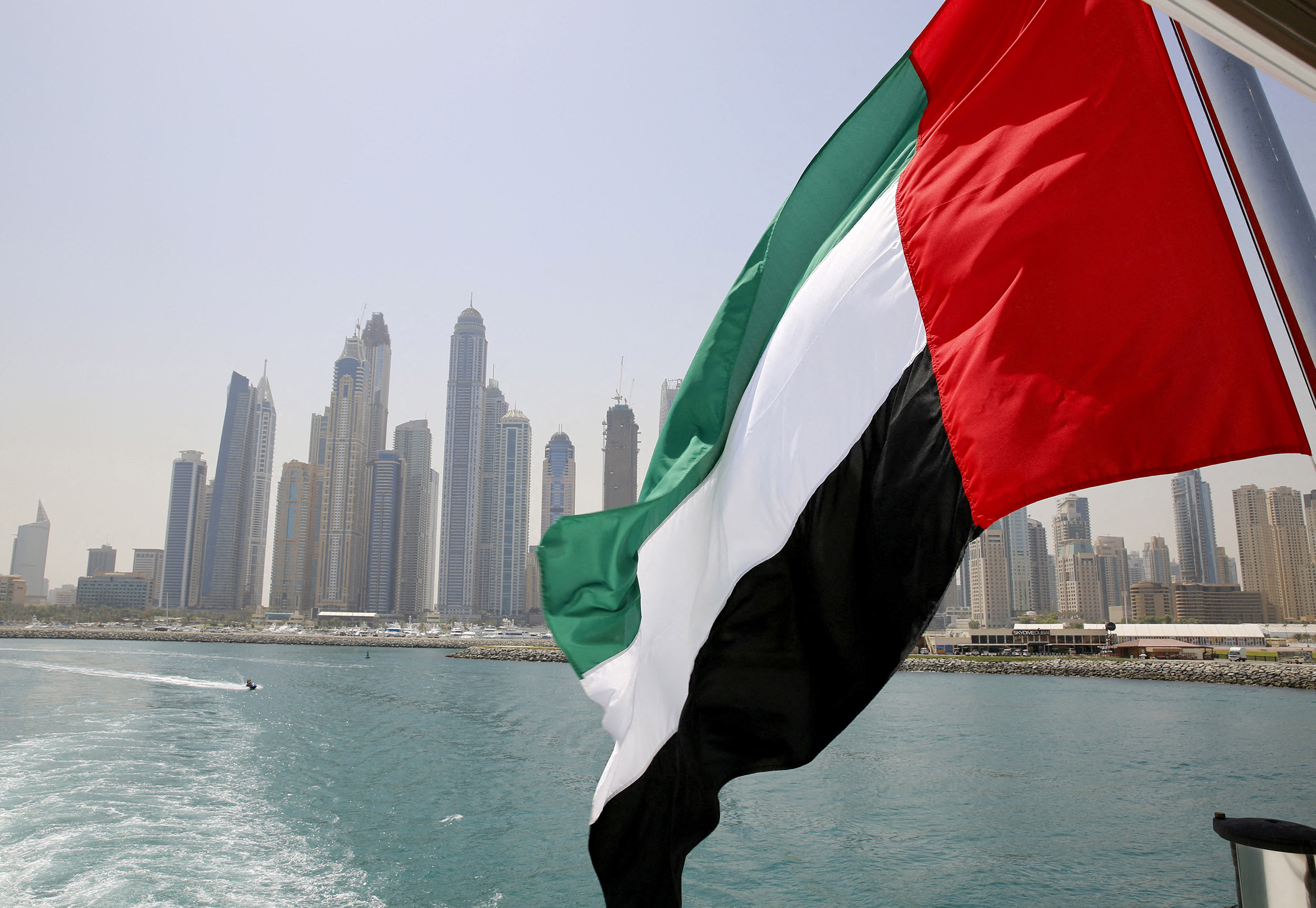 FILE PHOTO: UAE flag flies over a boat at Dubai Marina